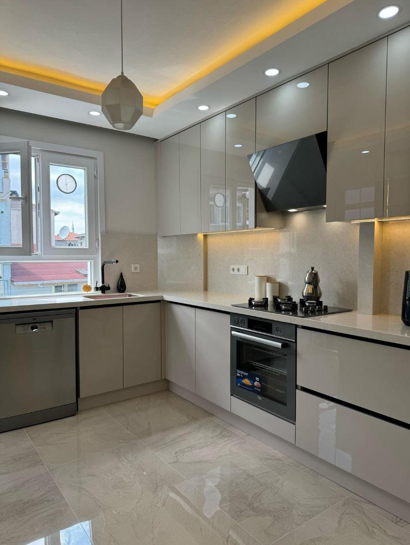 Derin lacivert halı, sıcak ahşap mobilyalar ve yumuşak doğal ışıkla rahat fildişi oturma odası