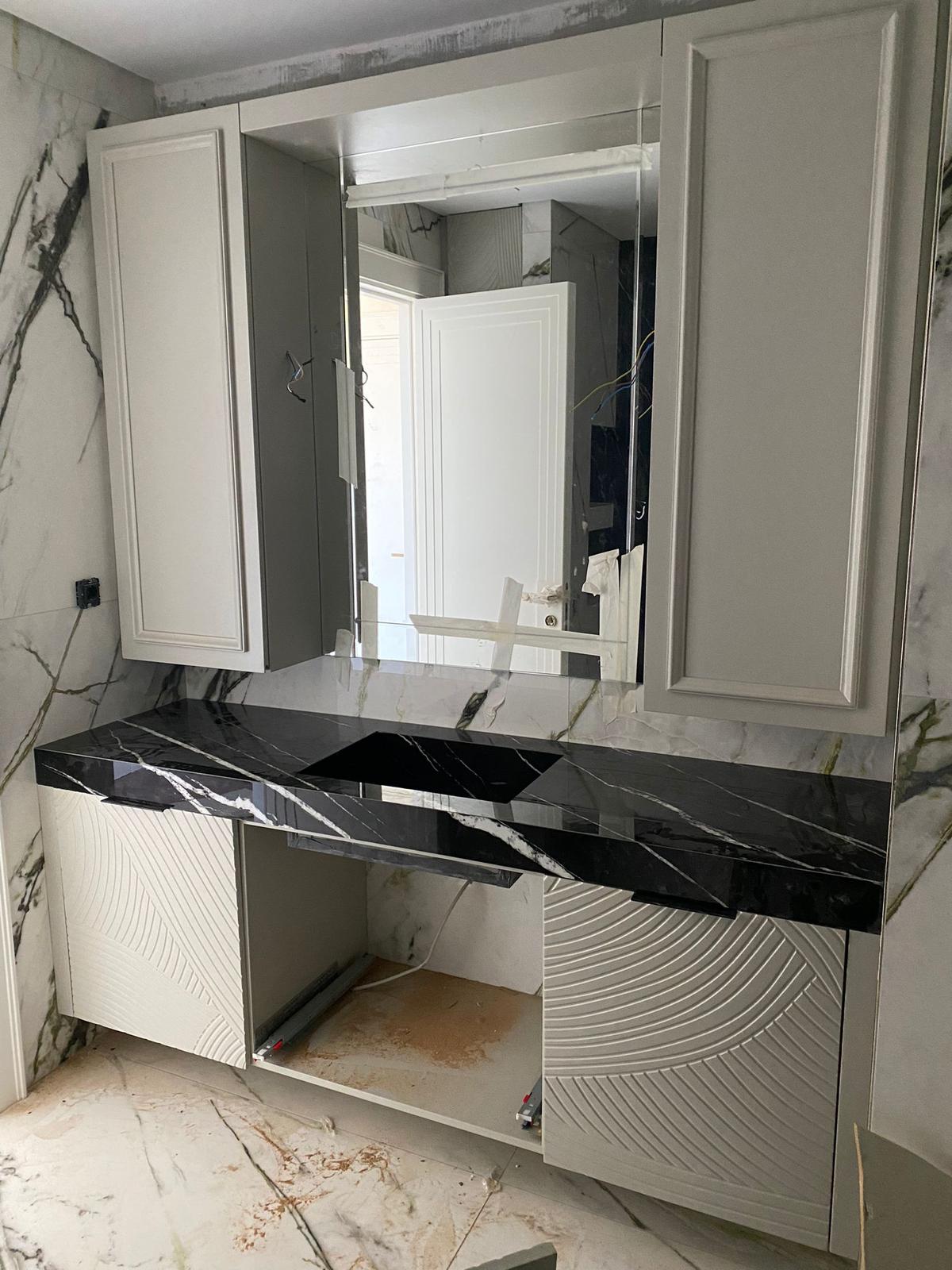 Modern lacivert kadife berjer, şık ahşap ayaklar ve yumuşak minderlerle aydınlık bir odada