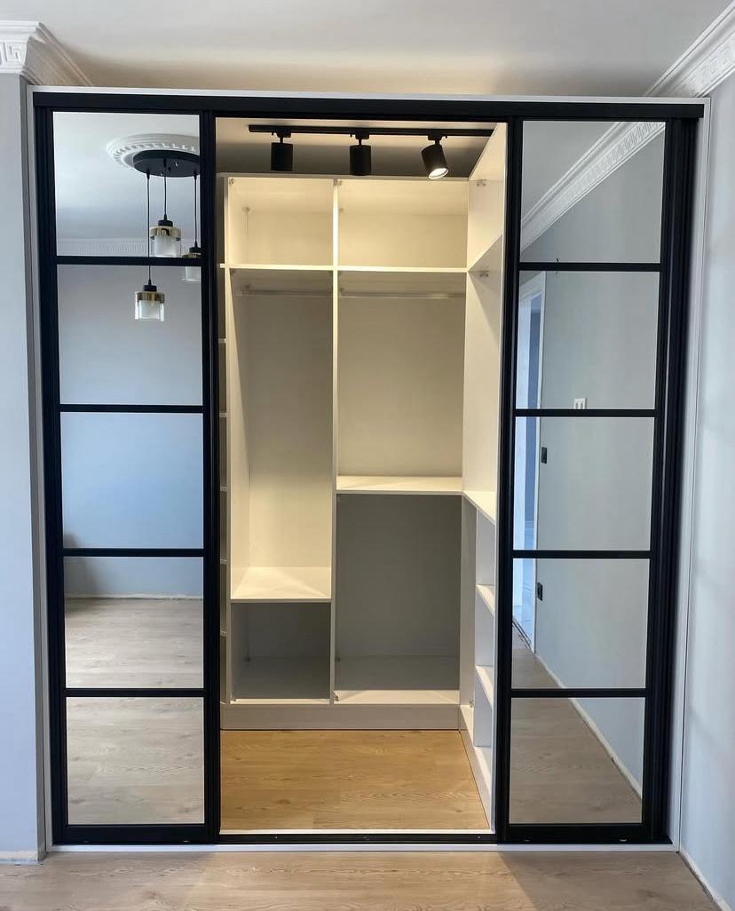 Siyah mat metal kitaplık, sıcak ahşap raflar ve modern odada kitaplar ve dekoratif eşyalarla dolu